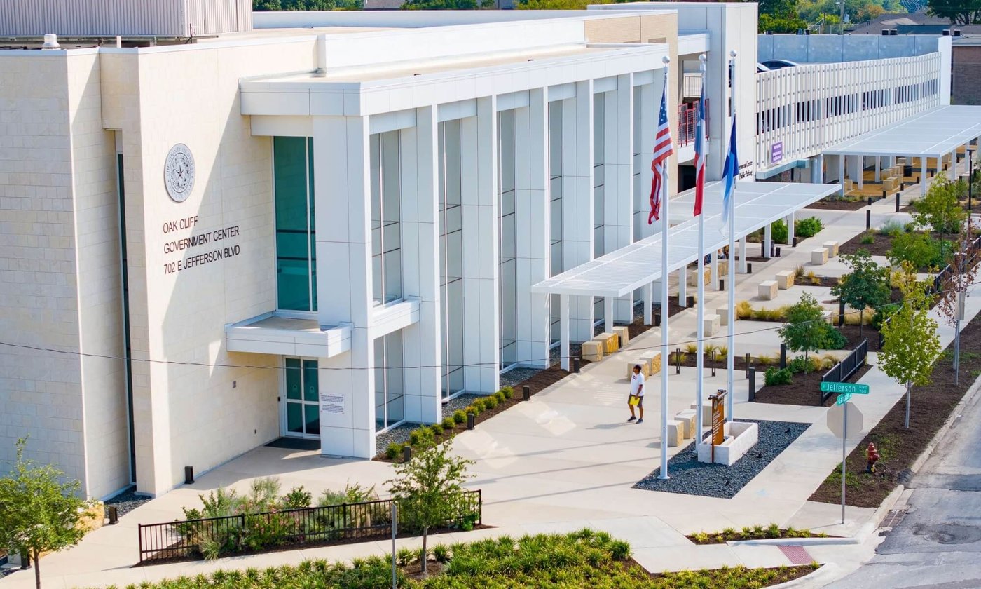 Exterior view of the Oak Cliff Government Center in Dallas, Texas, with American and Texas flags at the entrance